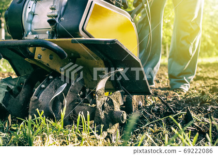 Grass and plowed soil nuggets during motor cultivator outdoor garden work 69222086