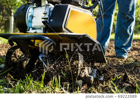 Grass and plowed soil nuggets during motor cultivator farm season work 69222089
