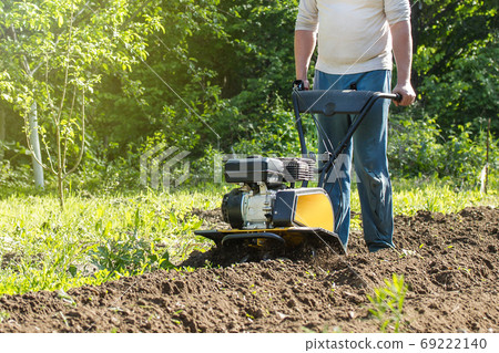 A man plowing soil by motor cultivator 69222140