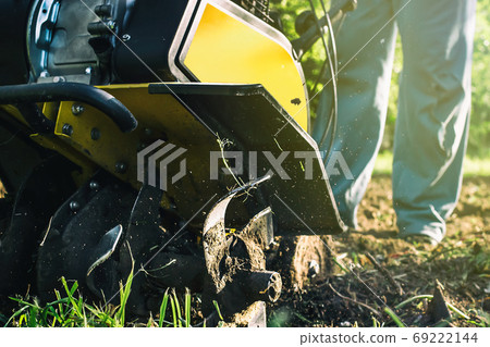 A man plowing a soil by motor cultivator bottom view A man plowing a soil by motor cultivator bottom view 69222144