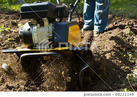 A close up view on working motor cultivator A close up view on working motor cultivator 69222149