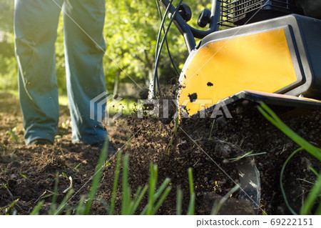 A close up view on process of working motor cultivator A close up view on process of working motor cultivator 69222151