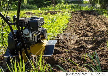A close up view on motor cultivator during spring garden works A close up view on motor cultivator during spring garden works 69222152