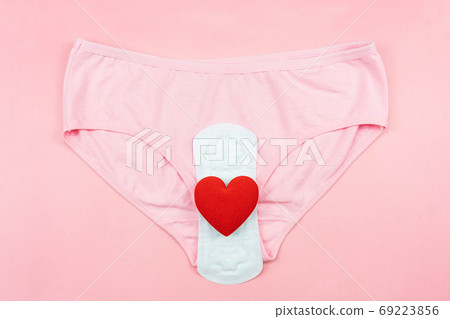Top view white sanitary napkin,red heart and pink underpants isolated on pink background. Woman hygiene, Concept of critical days, menstruation,health care Top view white sanitary napkin,red heart and pink underpants isolated on pink background. Woman hygiene, Concept of critical days, menstruation,health care 69223856