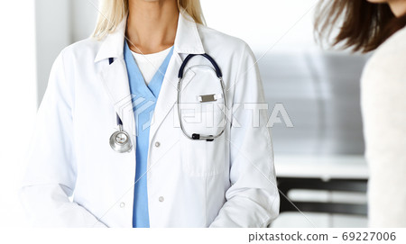 Unknown woman-doctor communicating with female patient. Physician checks medical history record and exam results, close-up. Medicine concept Unknown woman-doctor communicating with female patient. Physician checks medical history record and exam results, close-up. Medicine concept 69227006