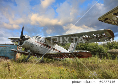 Airplane cemetery in the field against cloudy blue sky Airplane cemetery in the field against cloudy blue sky 69227346