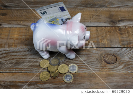 Pile of euro coins and a piggy bank 69229020