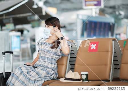 Young female wearing face mask and using mobile smartphone in ai 69229285