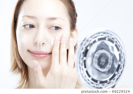 Woman applying foundation cream 69229324