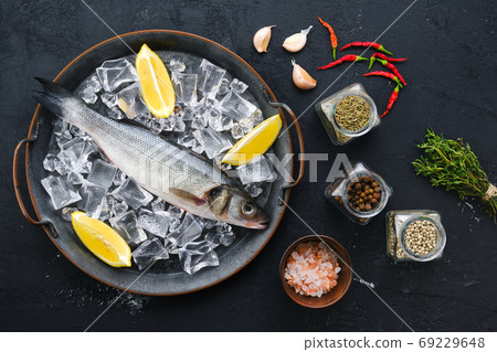 Raw seabass fish on wooden background 69229648