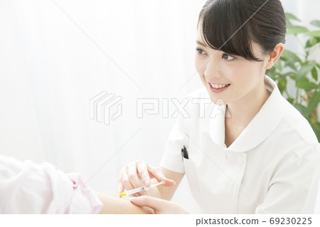 A nurse who gives an injection A nurse who gives an injection 69230225