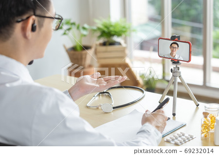 asian man patient In the screen smartphone. Online consultation speaking to patient . 69232014