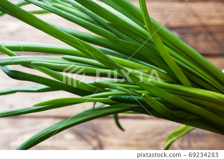 Green onions or shallots on a wooden background with copy space. 69234283