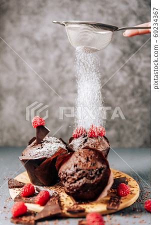 chocolate cupcakes with raspberries and bitter chocolate close-up on a light background chocolate cupcakes with raspberries and bitter chocolate close-up on a light background 69234367