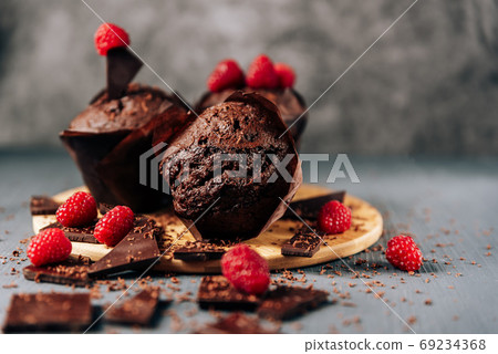 chocolate cupcakes with raspberries and bitter chocolate close-up on a light background 69234368
