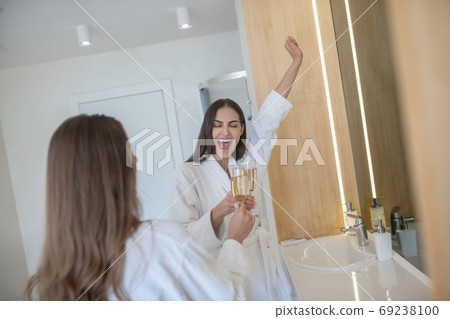 Two pretty girls enjoying together and drinking champagne Two pretty girls enjoying together and drinking champagne 69238100