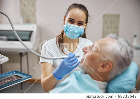 Beautiful female dentist in the middle of a dental procedure Beautiful female dentist in the middle of a dental procedure 69238642