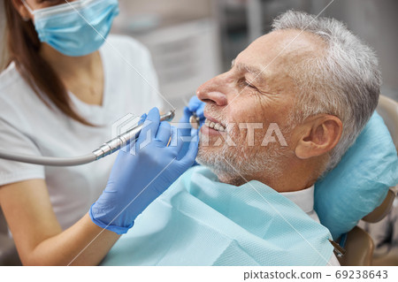 Positive elderly gentleman having his teeth treated Positive elderly gentleman having his teeth treated 69238643