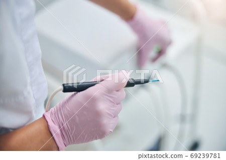 Qualified cosmetologist preparing for an electrosurgical procedure Qualified cosmetologist preparing for an electrosurgical procedure 69239781