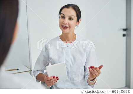 Friendly Caucasian woman dermatologist consulting her patient Friendly Caucasian woman dermatologist consulting her patient 69240638