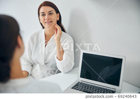 Smiling woman listening attentively to a doctor 69240643