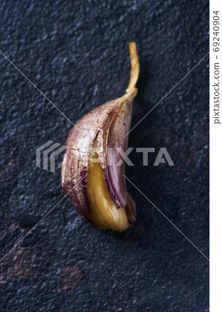 roasted garlic on a black stone surface roasted garlic on a black stone surface 69240904