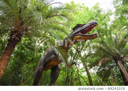 Dinosaur statue in the forest park / Spinosaurus dinosaur or spi Dinosaur statue in the forest park / Spinosaurus dinosaur or spi 69241018