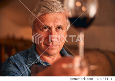 Handsome man holding glass of red wine Handsome man holding glass of red wine 69241104