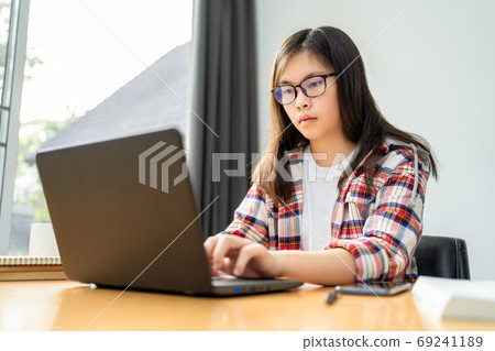 Young Asian female student working and studying from home during Young Asian female student working and studying from home during 69241189