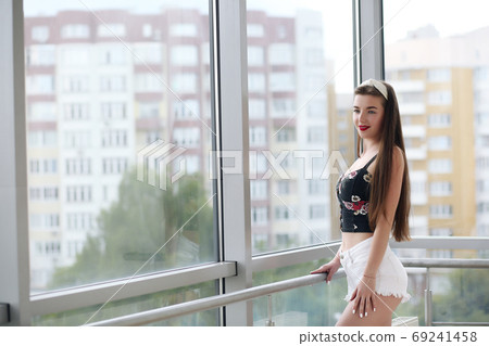 Surprised brunette young woman in denim shorts, studio Surprised brunette young woman in denim shorts, studio 69241458