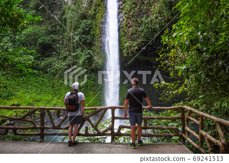 Two tourists looking at the La Fortuna Waterfall in Costa Rica 69241513