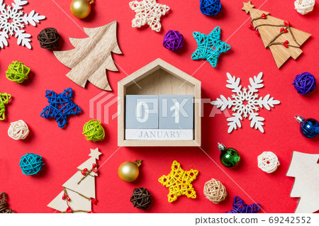 Top view of calendar on red background made of holiday decorations and toys. Christmas ornament concept 69242552