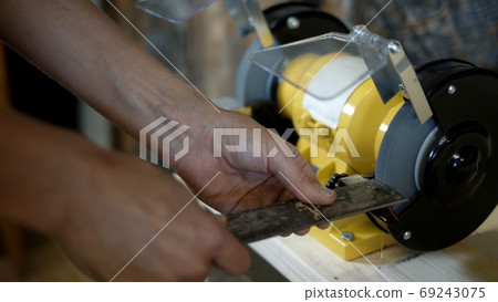 Electric sharpener and blade close up, hands cutting knife Electric sharpener and blade close up, hands cutting knife 69243075