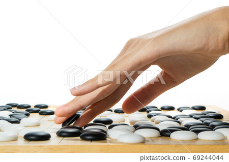 close up of player hand with weiqi stone close up of player hand with weiqi stone 69244044