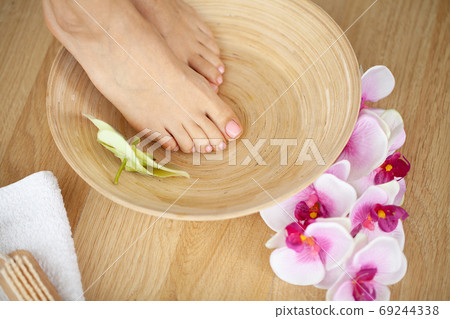 Closeup photo of a female feet at spa salon on pedicure procedure Closeup photo of a female feet at spa salon on pedicure procedure 69244338
