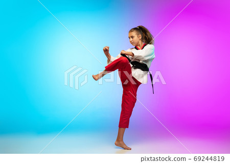 Karate, taekwondo girl with black belt isolated on gradient background in neon light 69244819
