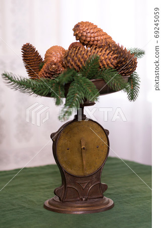 Stylish antique decor with pine cones. A handful of pine cones on an antique bronze scale 69245059