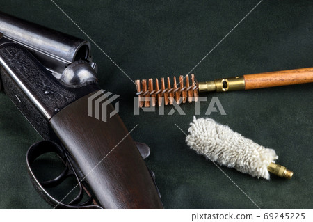 Old Shotgun on Outdoor Coat with Cleaning Equipment Old Shotgun on Outdoor Coat with Cleaning Equipment 69245225