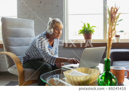 Senior woman studying at home, getting online courses Senior woman studying at home, getting online courses 69245410