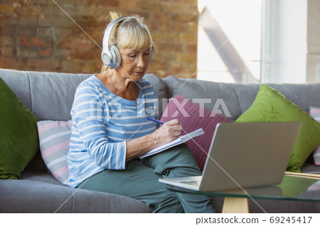 Senior woman studying at home, getting online courses 69245417