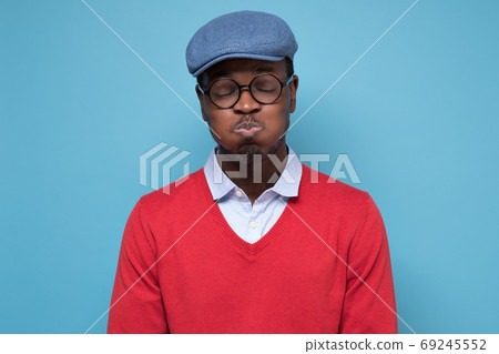 Young handsome african man puffing cheeks with funny face holding breath. 69245552