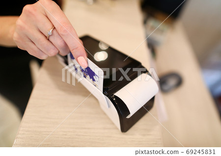 Female hand employee pays through the terminal 69245831