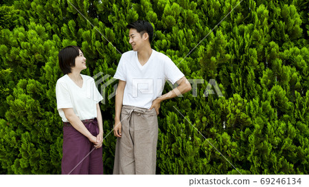 一對夫婦帶著微笑穿著放鬆穿綠色背 69246134