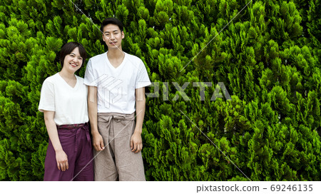 A couple with a smile wearing relaxing wear Green back 69246135