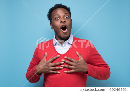 Friendly african american man keeps hands on heart, being touched by compliment Friendly african american man keeps hands on heart, being touched by compliment 69246561