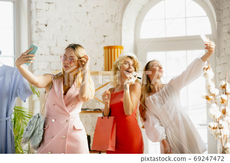 Wear, clothing shop during sales, summer or autumn collection. Young women looking for new attire Wear, clothing shop during sales, summer or autumn collection. Young women looking for new attire 69247472