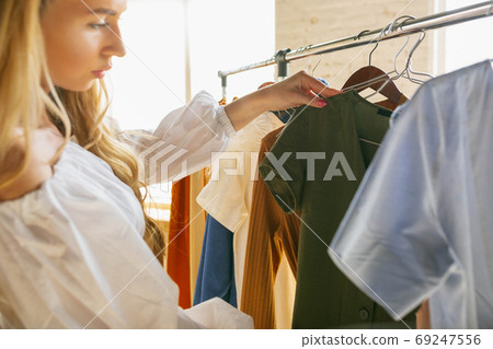 Wear, clothing shop during sales, summer or autumn collection. Young women looking for new attire Wear, clothing shop during sales, summer or autumn collection. Young women looking for new attire 69247556