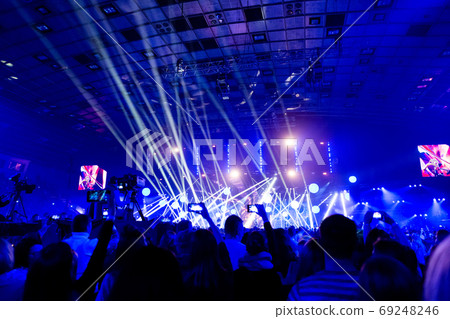 Silhouettes of crowds of spectators at a concert with smartphones in their hands. Silhouettes of crowds of spectators at a concert with smartphones in their hands. 69248246