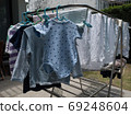 Baby clothes and diapers are exposed to the sun in the backyard. 69248604