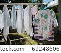 Baby clothes and diapers are exposed to the sun in the backyard. 69248606